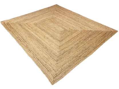 Geometric-patterned jute rug, natural beige, flat-laying, diagonal view.