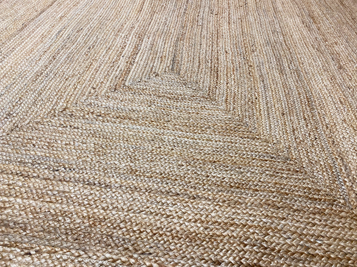 Jute rug close-up: woven texture with a raised pattern in natural tones