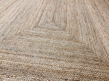 Jute rug close-up: woven texture with a raised pattern in natural tones