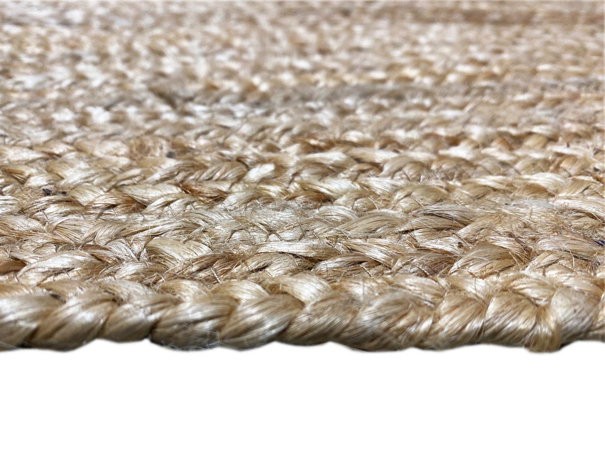 Jute rug edge with short, braided fringes in natural tones