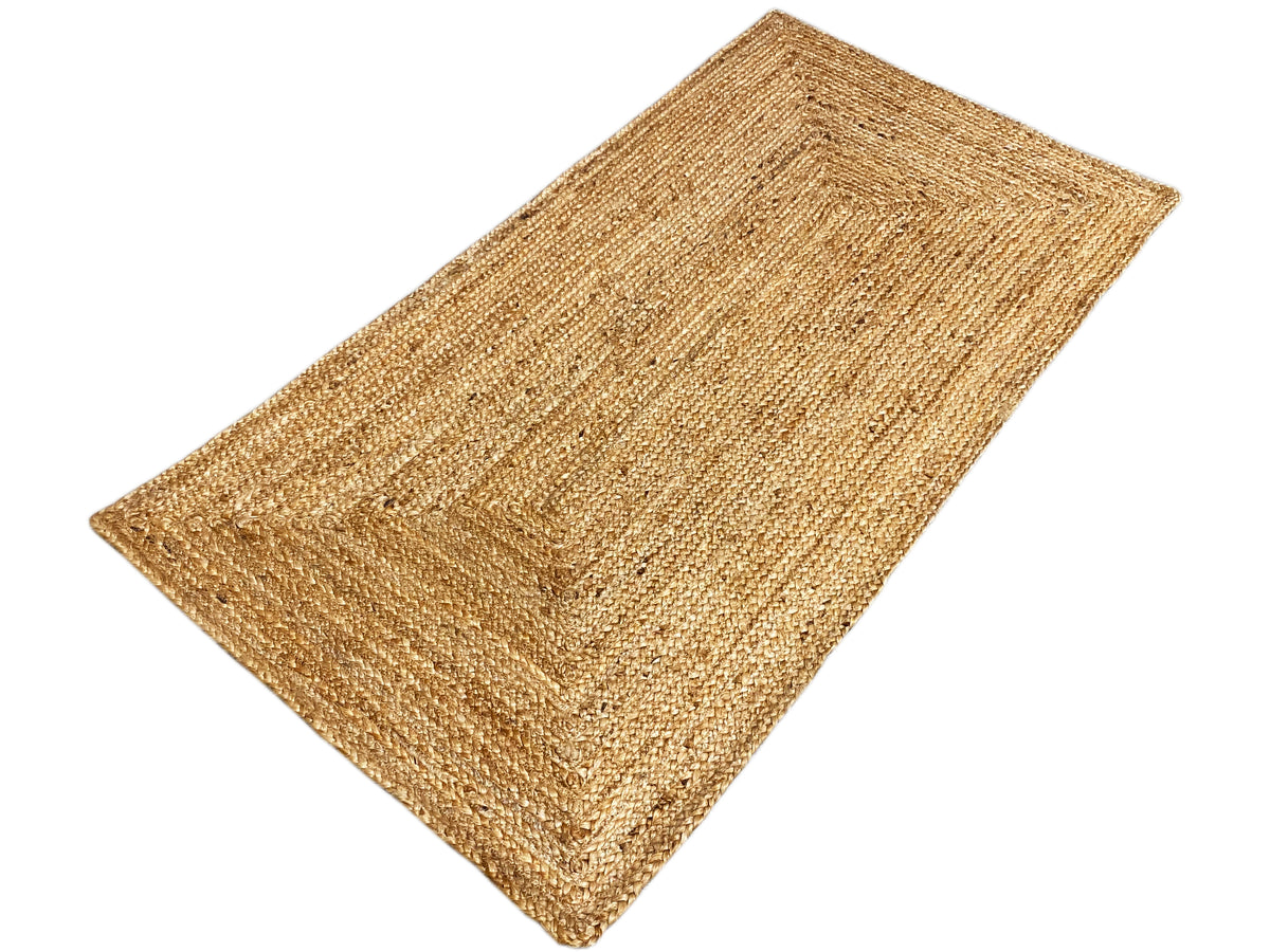Rectangular jute rug, viewed from above at an angle, natural beige color, woven lines