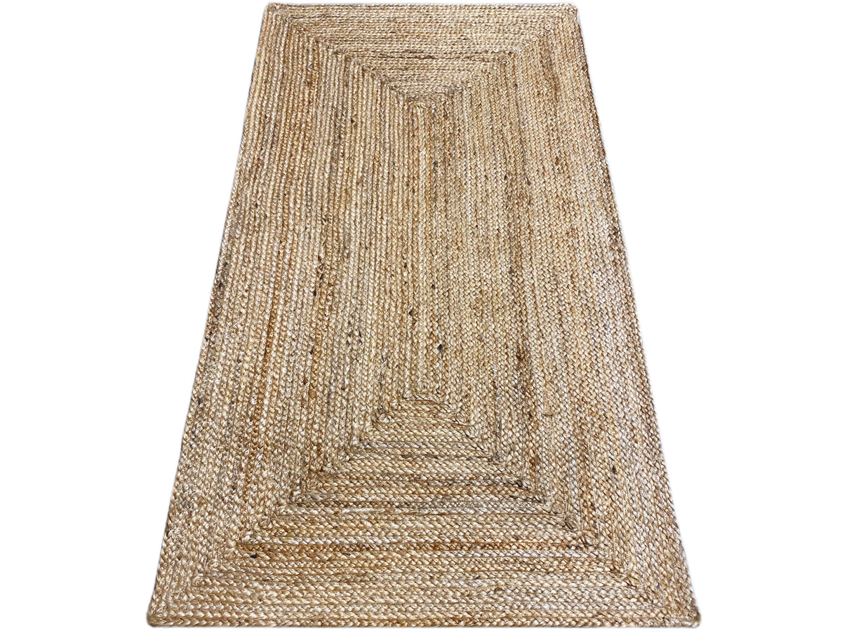 Jute rug angled view, beige weave with a boho border pattern and hemmed edges