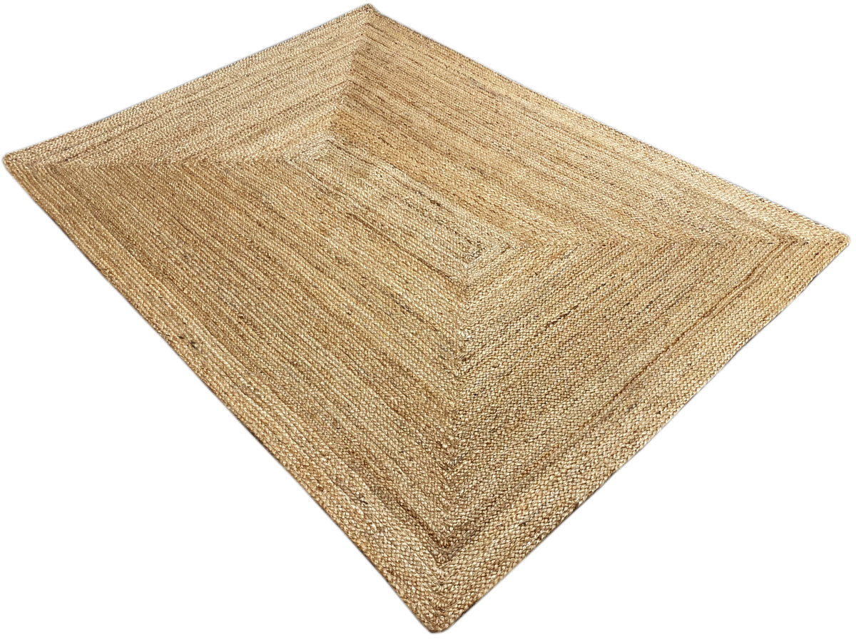 Rectangular natural jute rug with a square decorative pattern and visible woven texture