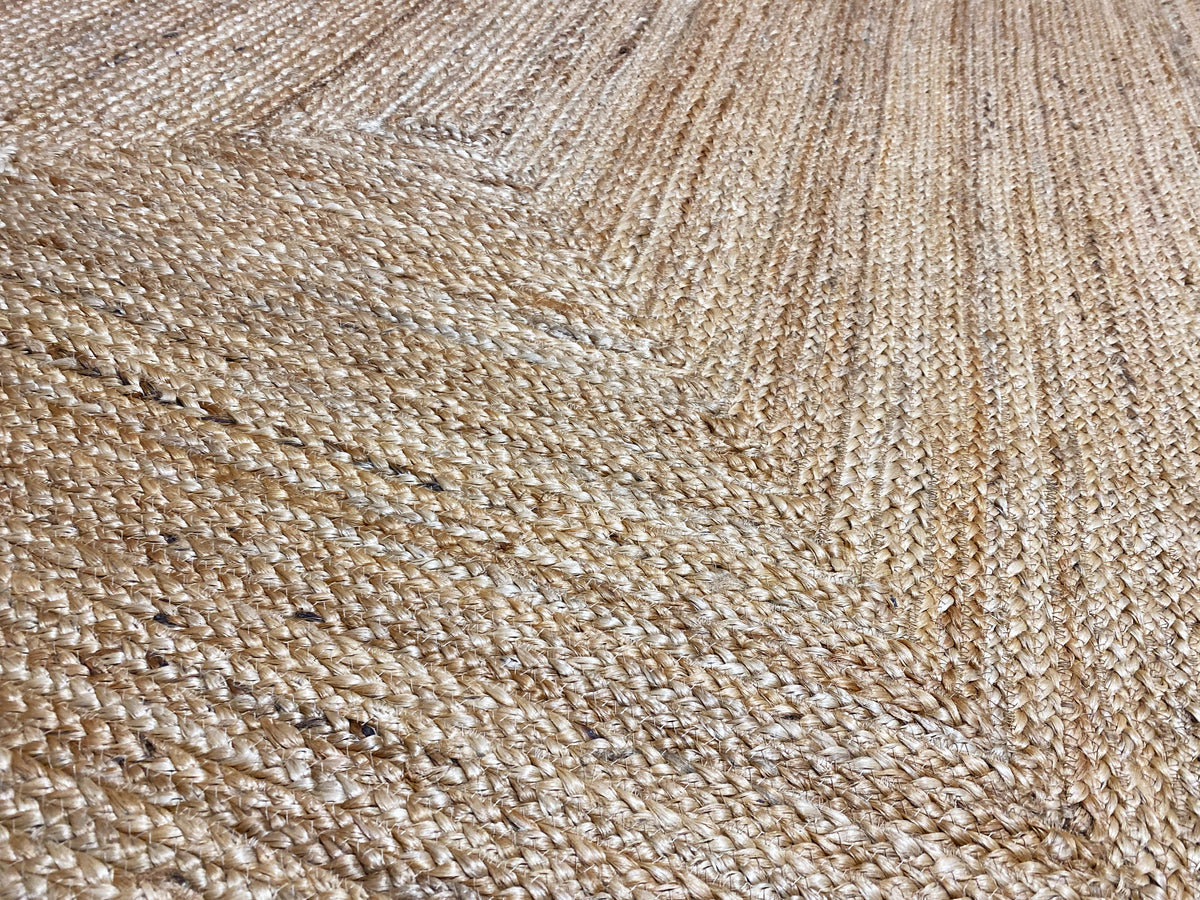 Close-up of a natural jute rug with fine woven threads and a distinctive embossed pattern