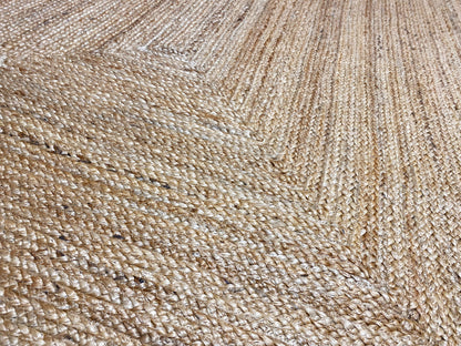 Close-up of a natural jute rug with fine woven threads and a distinctive embossed pattern