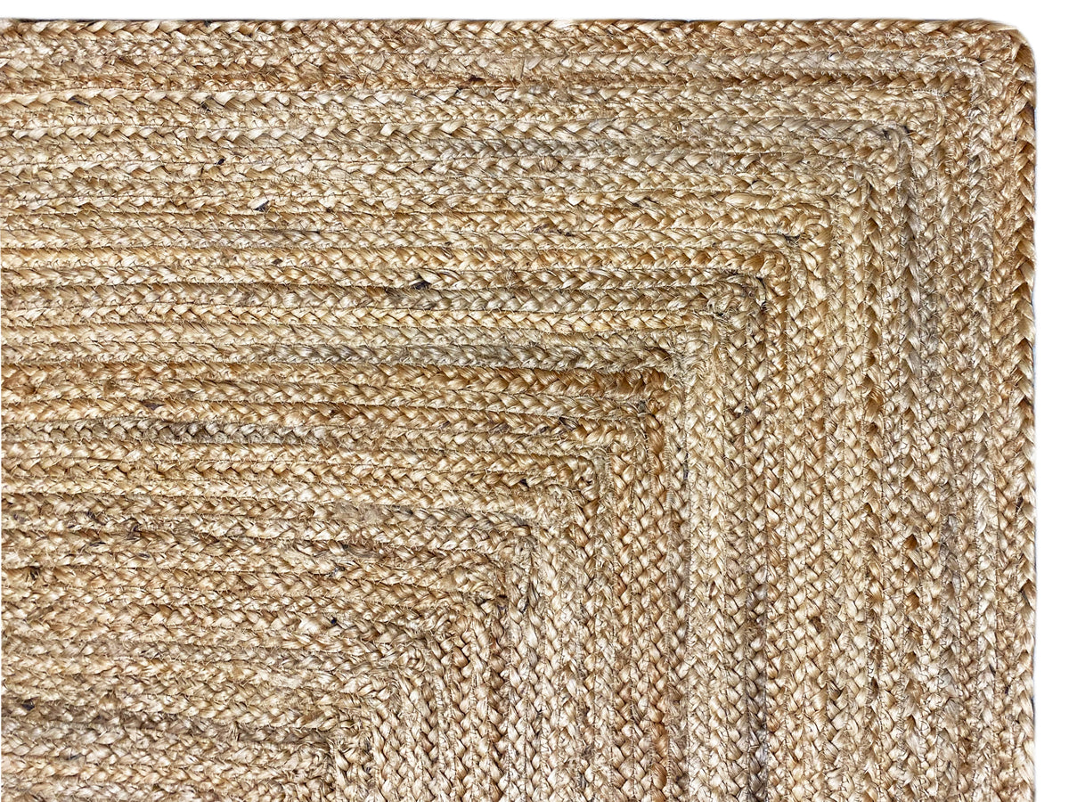 Jute rug: detail of the woven jute, beige thread pattern, and raised edge
