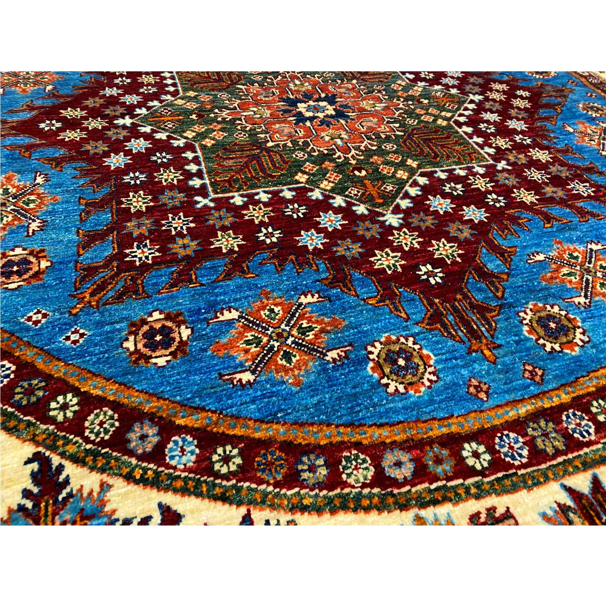 Close-up of the carpet pattern: blue field with red, green, and white ornaments