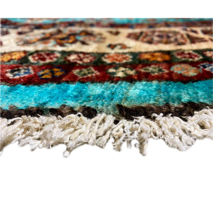 Edge detail: turquoise rug with a braided fringe finish in beige and brown