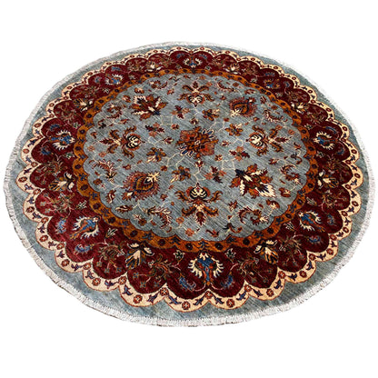 Round Kazak rug (176×175 cm) with a light blue base and contrasting, colorful ornaments.