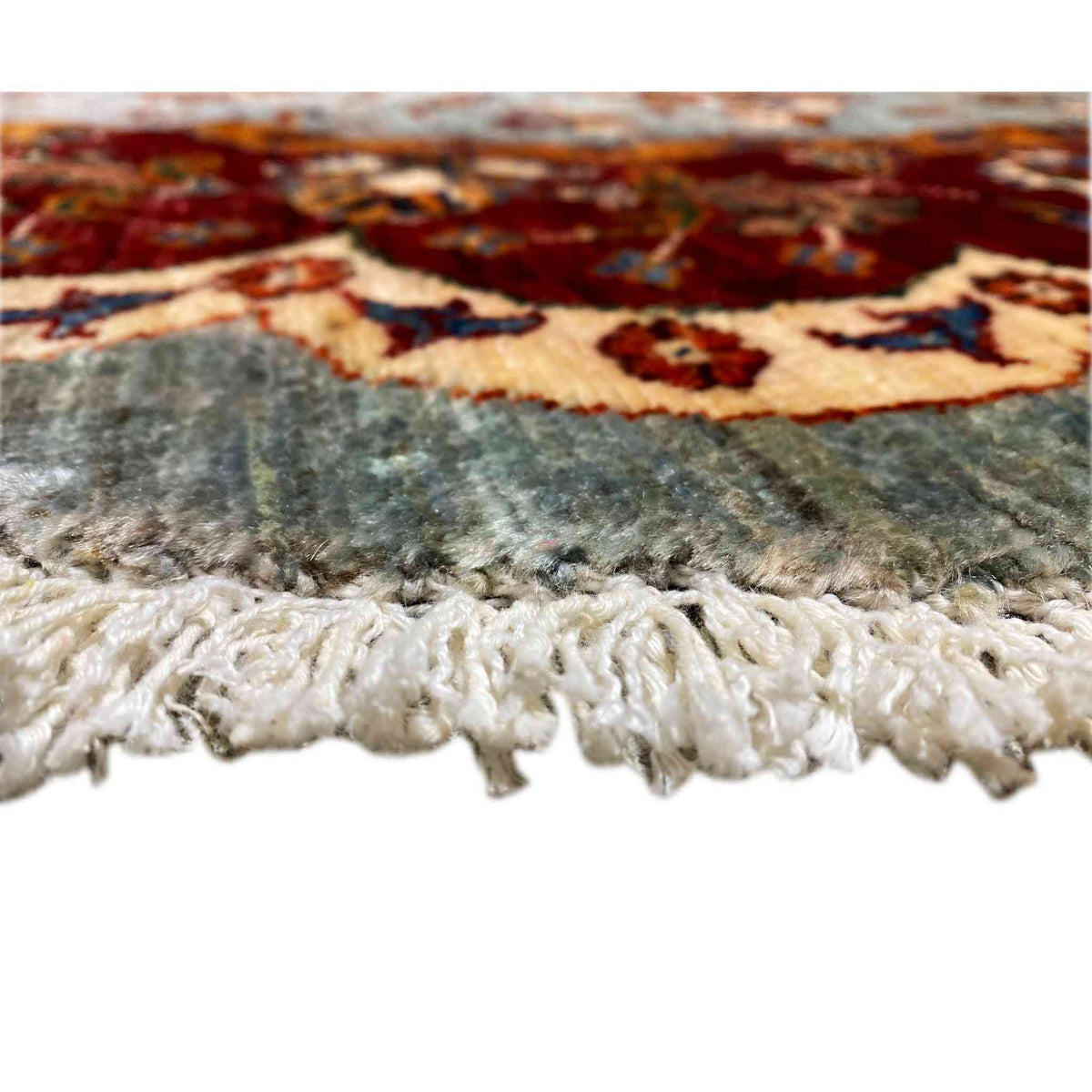 Kazakh rug at the edge with white fringes and a multicolored pattern visible underneath.
