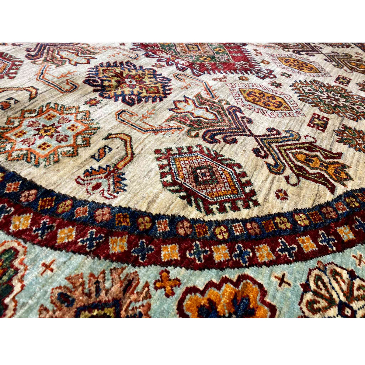 Close-up: woven rug with a beige background, colorful ornaments, and a decorative border
