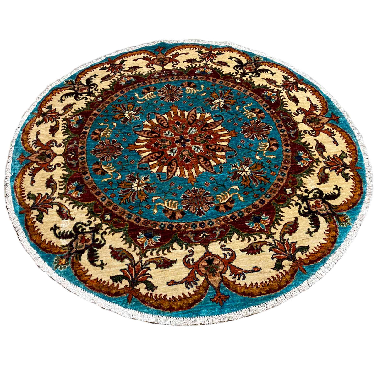 Round rug with a turquoise central motif and beige ornamental border, embroidered in color.