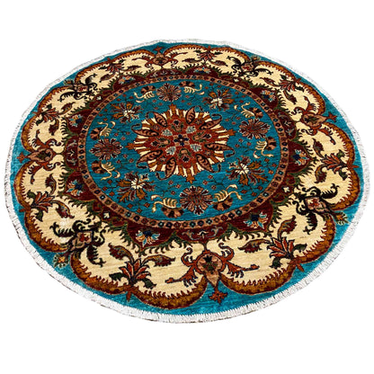 Round rug with a turquoise central motif and beige ornamental border, embroidered in color.