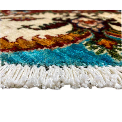 Carpet edge with a white fringed finish and visible turquoise woven surface.