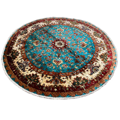 Round rug with a turquoise medallion, beige ornaments, and a dark border