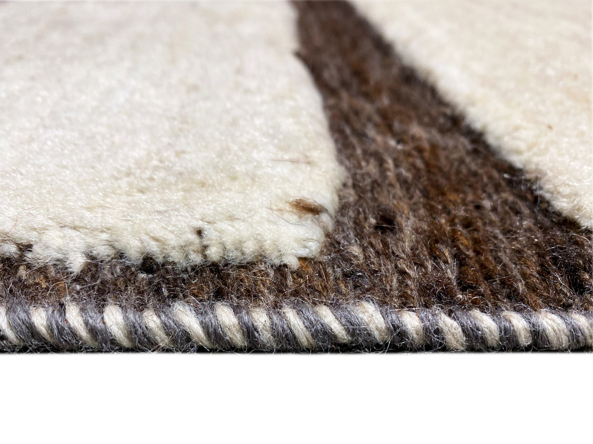 Carpet pile detail: cream and brown fibers, visible selvedge edge
