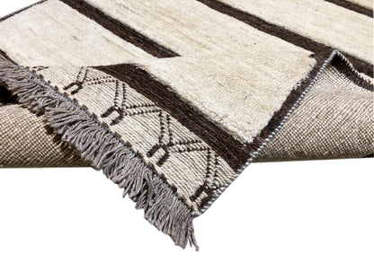 Close-up detail: woven ornaments and fringes along the edge of a kilim rug
