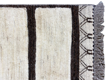 Close-up of the carpet edge: cream-colored stripes, dark trim, and fringe