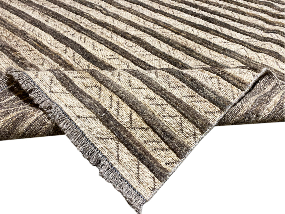 Detailed view of kilim rug: bound edges with fringes and striped weave pattern