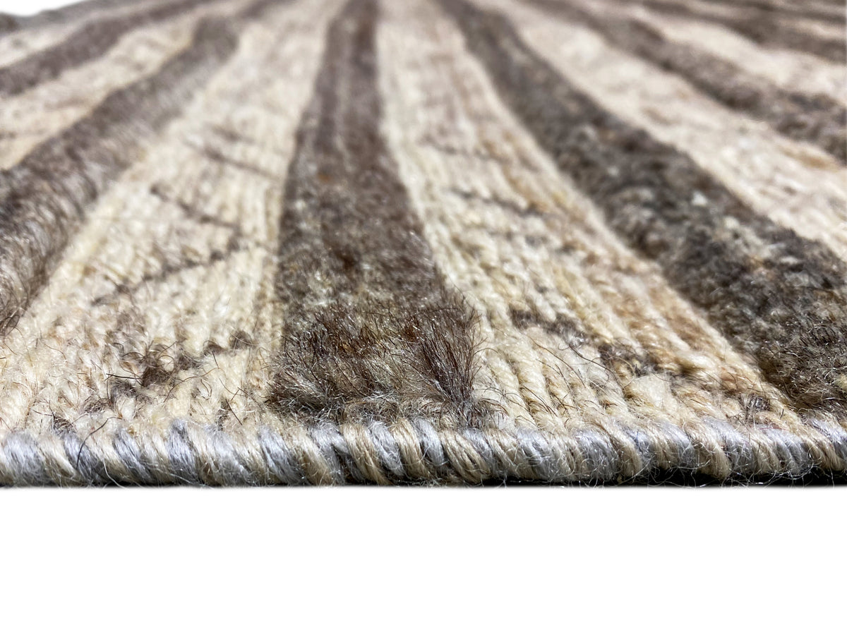 Surface detail of a kilim rug with pile and dark beige lines in a striped pattern