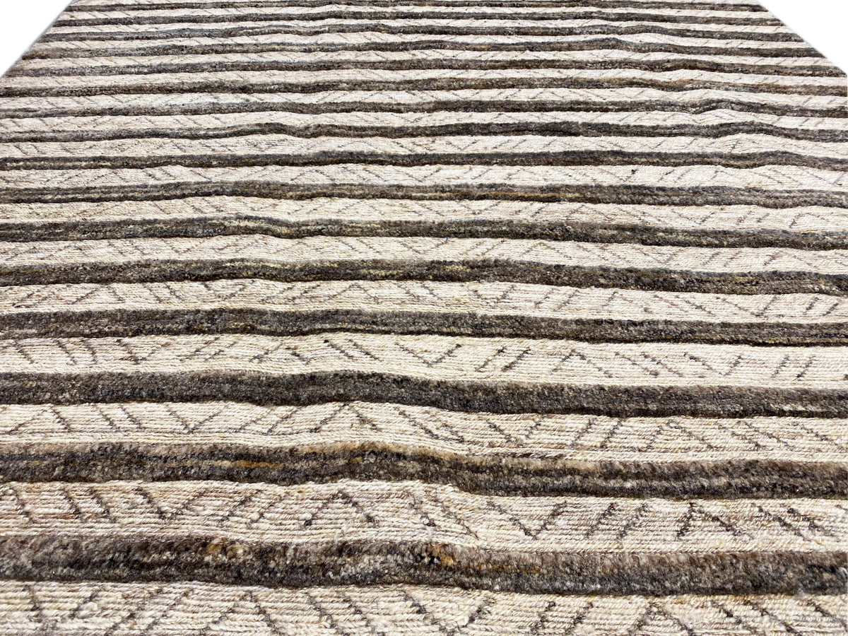 Close-up of a kilim rug: horizontal lines and patterns in beige and dark brown