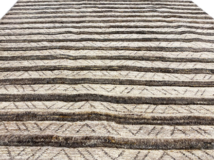 Close-up of a kilim rug: horizontal lines and patterns in beige and dark brown
