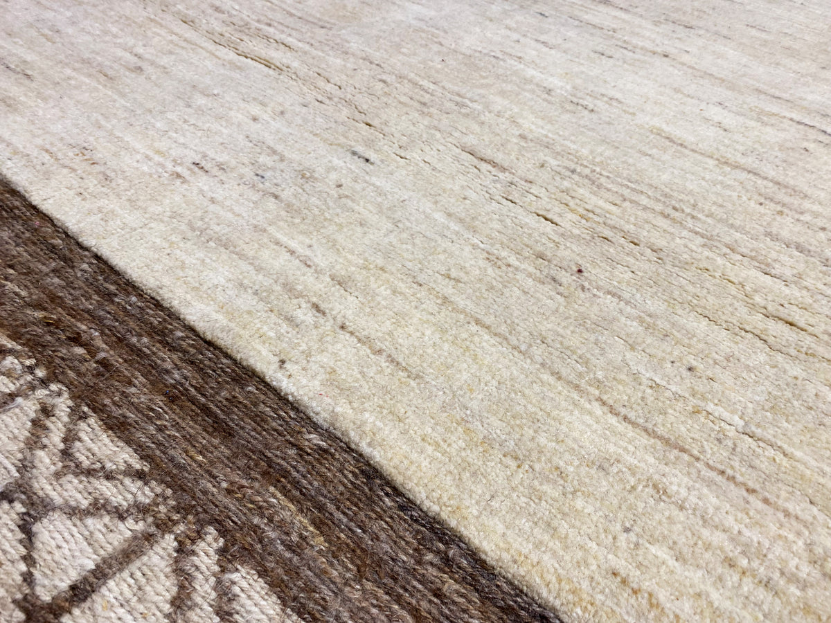 Kelim Gabbeh Teppich Nahaufnahme: Textur mit hellem Grund und dunklem Streifen mit Motiven