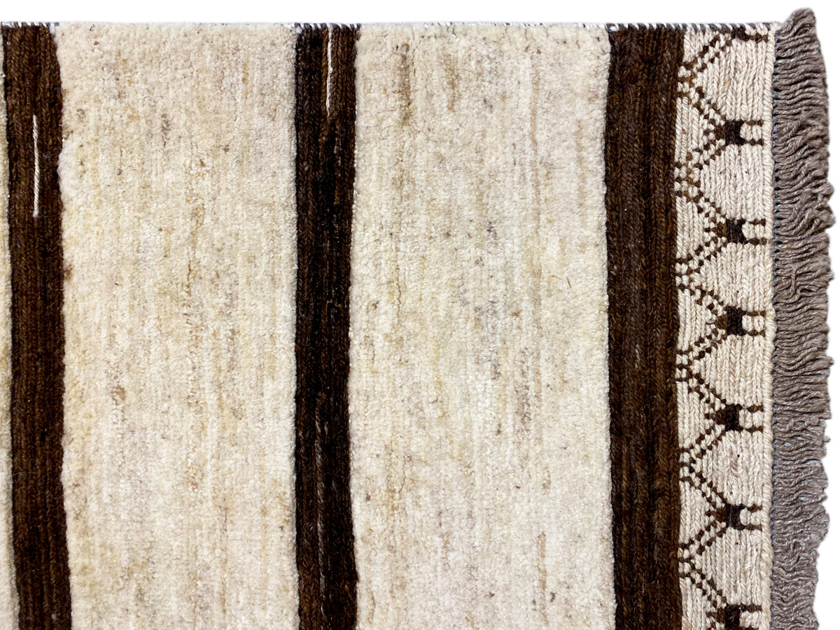 Nahansicht Kelim: beige Streifen, dunkelbraune Kanten, gewebtes Zickzack-Bordürchen