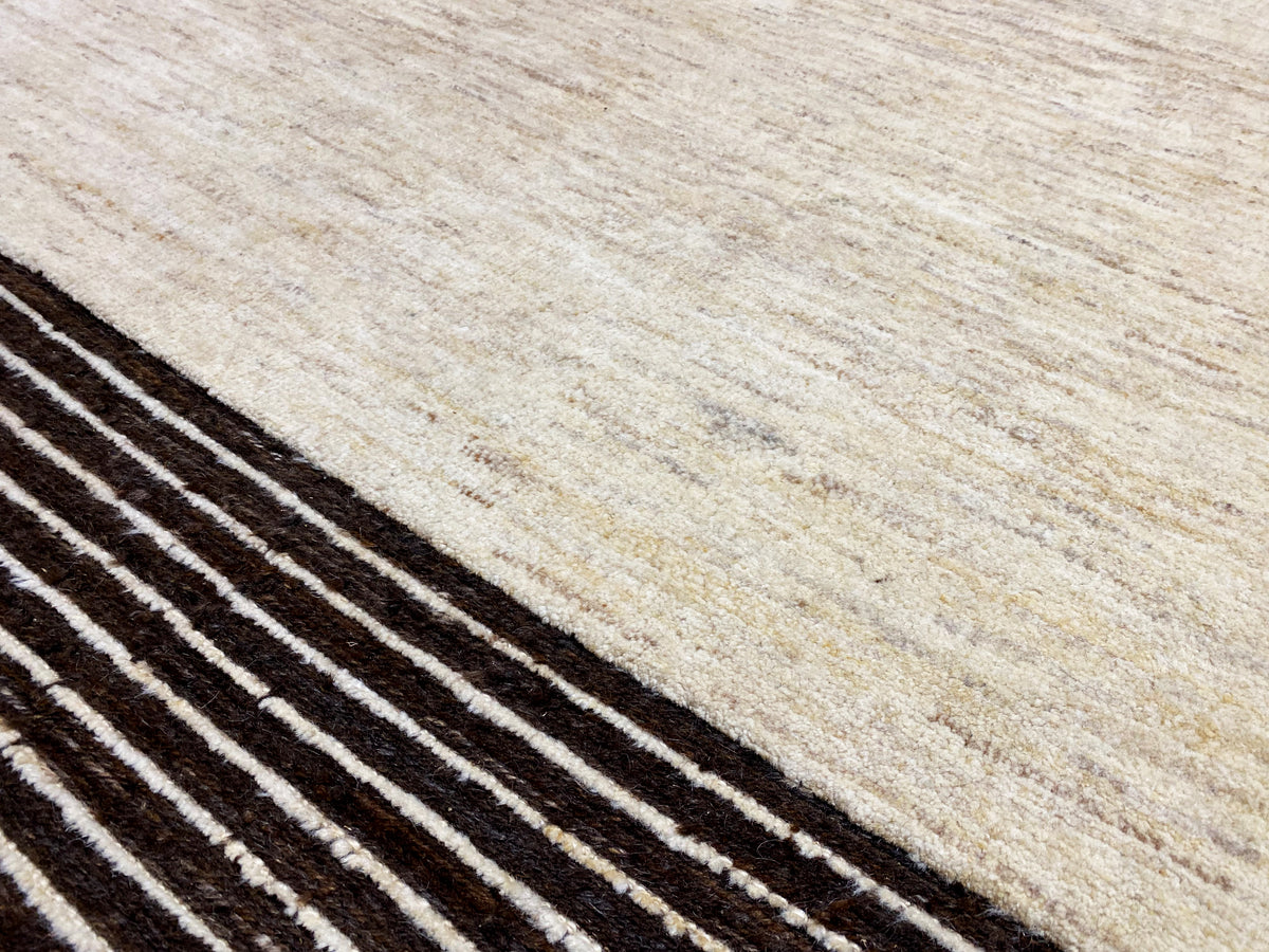 Teppichdetail mit beigem Grund und diagonalen Reihen schwarzer Streifen