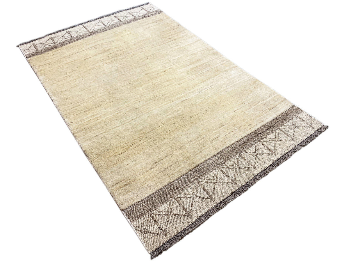 Gabbeh kilim rug, cream-colored texture with a dark brown patterned band along the side edge