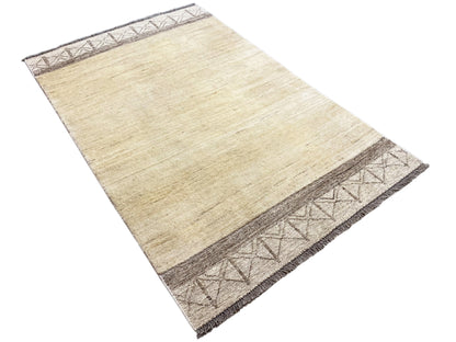 Gabbeh kilim rug, cream-colored texture with a dark brown patterned band along the side edge