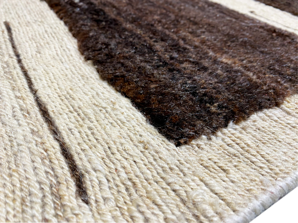 Detailansicht Kelim Gabbeh Teppich: geprägte Textur mit beigen und dunkelbraunen Mustern