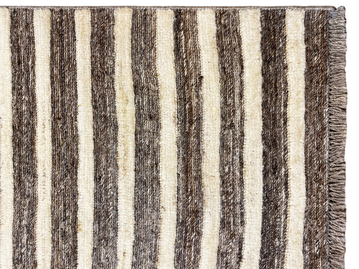 Kelim-Teppich Nahansicht: vertikale Streifen in Beige und Dunkelbraun, Rand mit Fransen