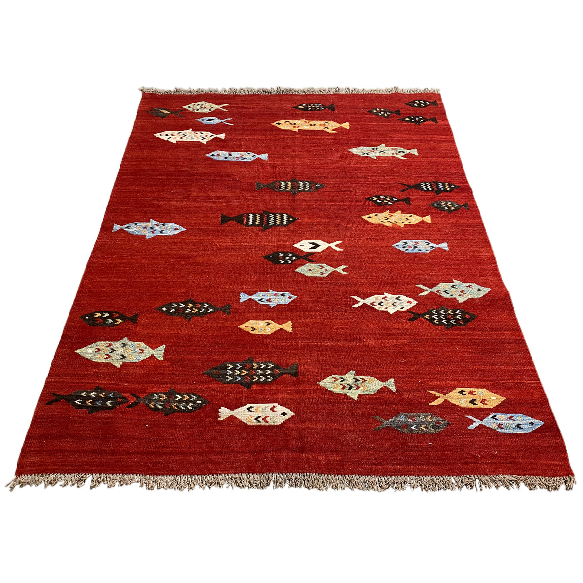 Red kilim rug with a triangular design, multicolored figures, and fringes