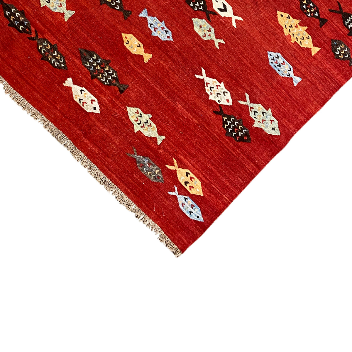 Close-up of the edge: red kilim rug with fringes and colorful patterns