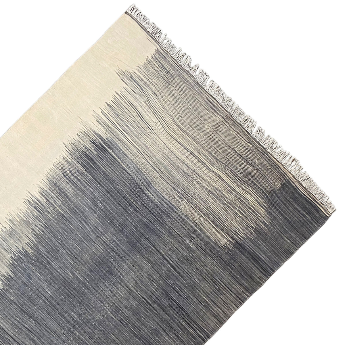 Kilim rug detail at the edge: fringe and light/dark stripes, gray and beige