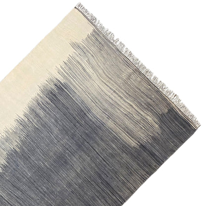 Kilim rug detail at the edge: fringe and light/dark stripes, gray and beige