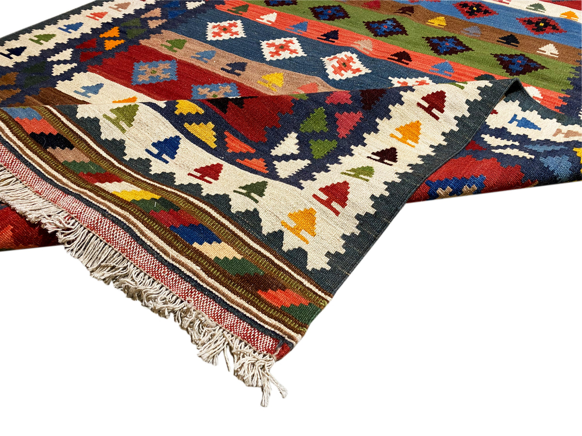 Kelim-Teppich mit buntem geometrischem Muster, dunkelblauem Grund und Fransen an der Kante