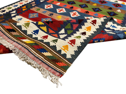 Kelim-Teppich mit buntem geometrischem Muster, dunkelblauem Grund und Fransen an der Kante