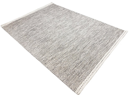Light gray kilim rug with a dot pattern, diagonally oriented view with a bound edge