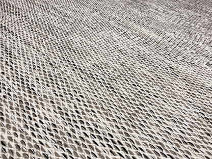 Detailed view of the kilim dot pattern: light gray, tightly woven surface with dark accents