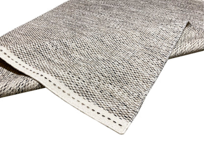 Kilim rug corner with polka-dot pattern, bound edge and short fringes, two-layer view