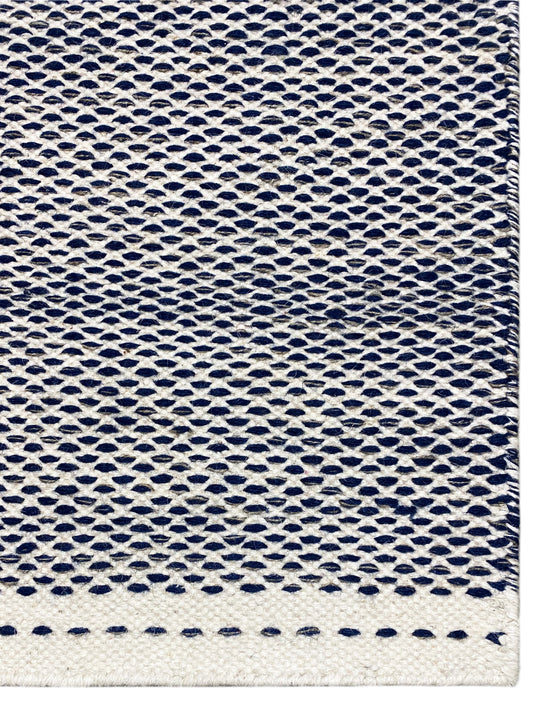 Kelim-Teppich Detail: rundes Webmuster in Blau mit heller Abschlusskante