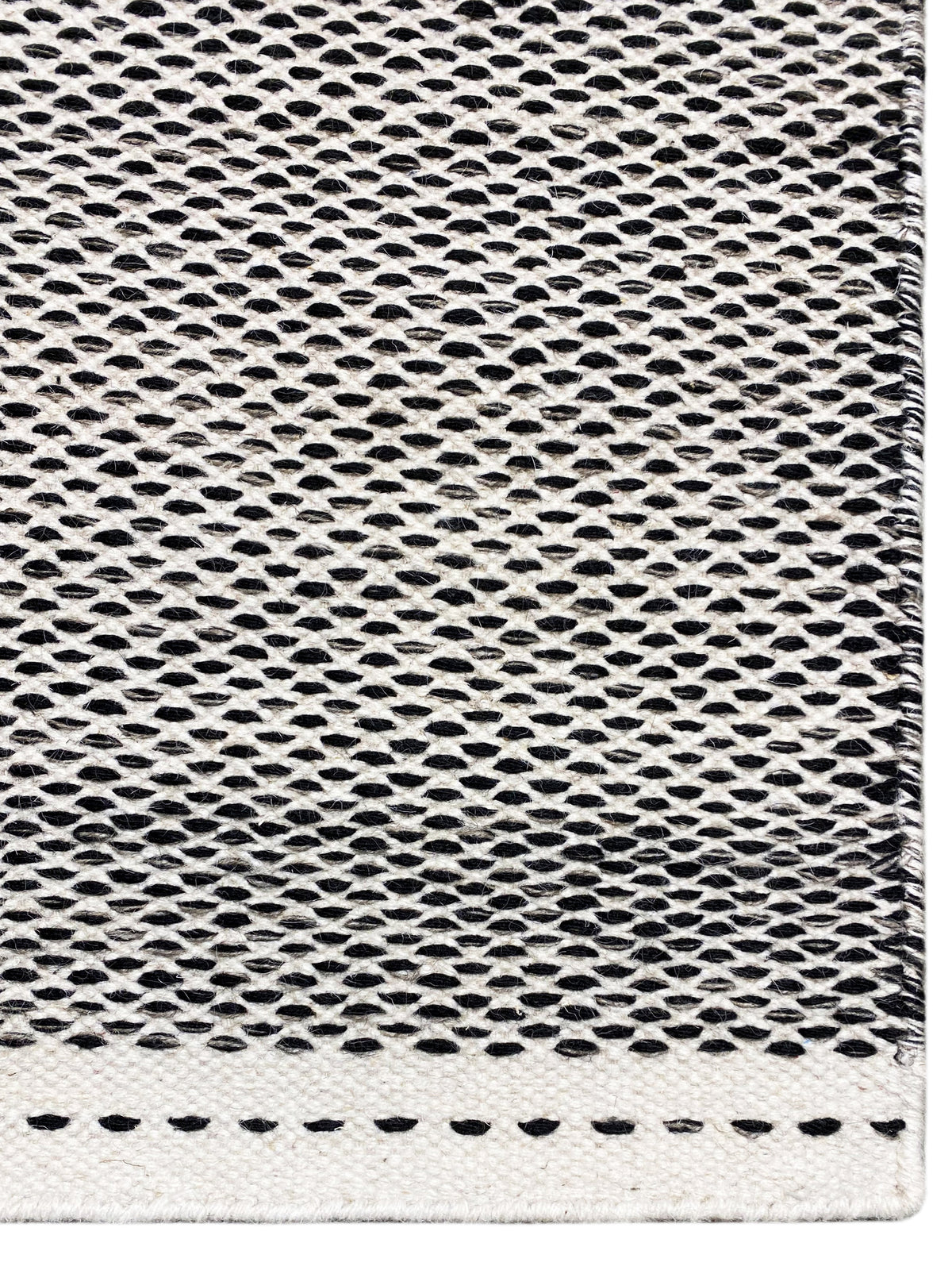 Kilim rug detail: fine hole-and-ring weave in dark gray with light edges