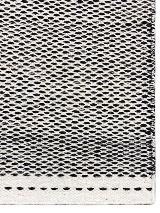 Kilim rug detail: fine hole-and-ring weave in dark gray with light edges