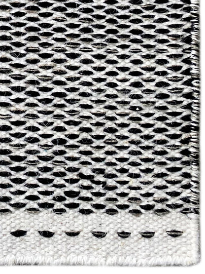 Kelim-Teppich Detailansicht: schwarz-weißes Lochmuster, gepunktete Ziernaht unten