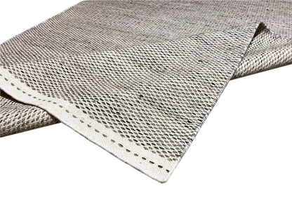 Kilim rug in silver, corner detail, woven pattern and bound edges