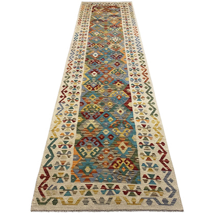 Kilim runner with a geometric mix of patterns in blue, turquoise, red, and beige, elongated