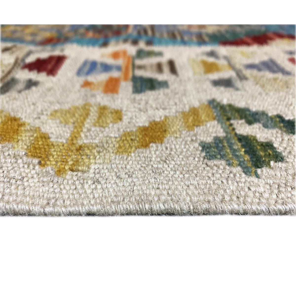 Detail of the kilim runner: pile/weave visible, colorful motifs in blue and ochre