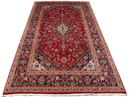 Red patterned rug in trapezoidal view with a medallion and surrounding ornamental border